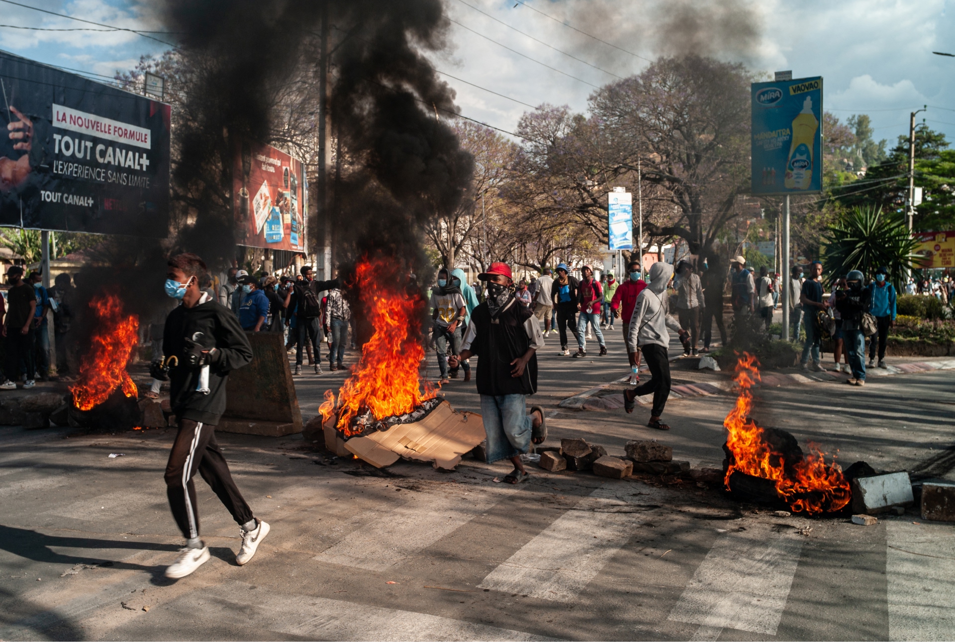 Jóvenes con mascarillas y barricadas con fuego en una protesta en Madagascar