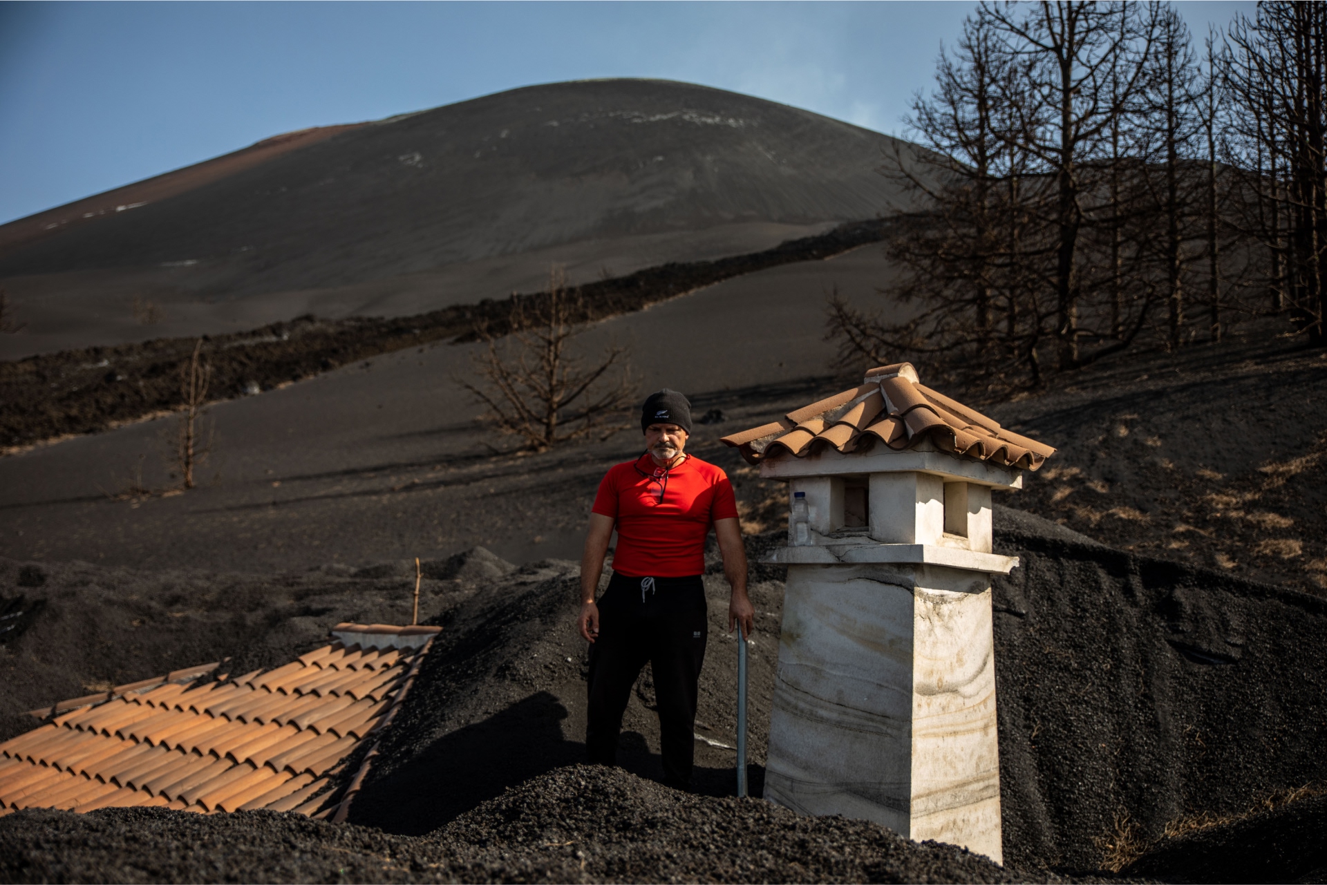 Hombre encima de un tejado quitando la ceniza
