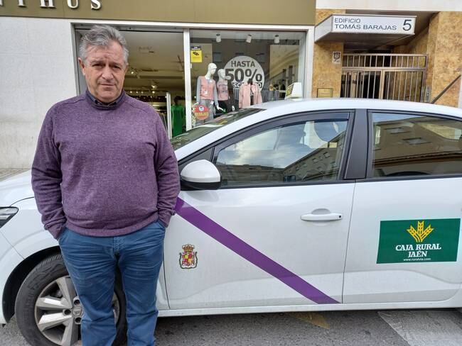 El taxista Juan Carlos Cañada sin mascarilla delante de su vehículo en Jaén.
