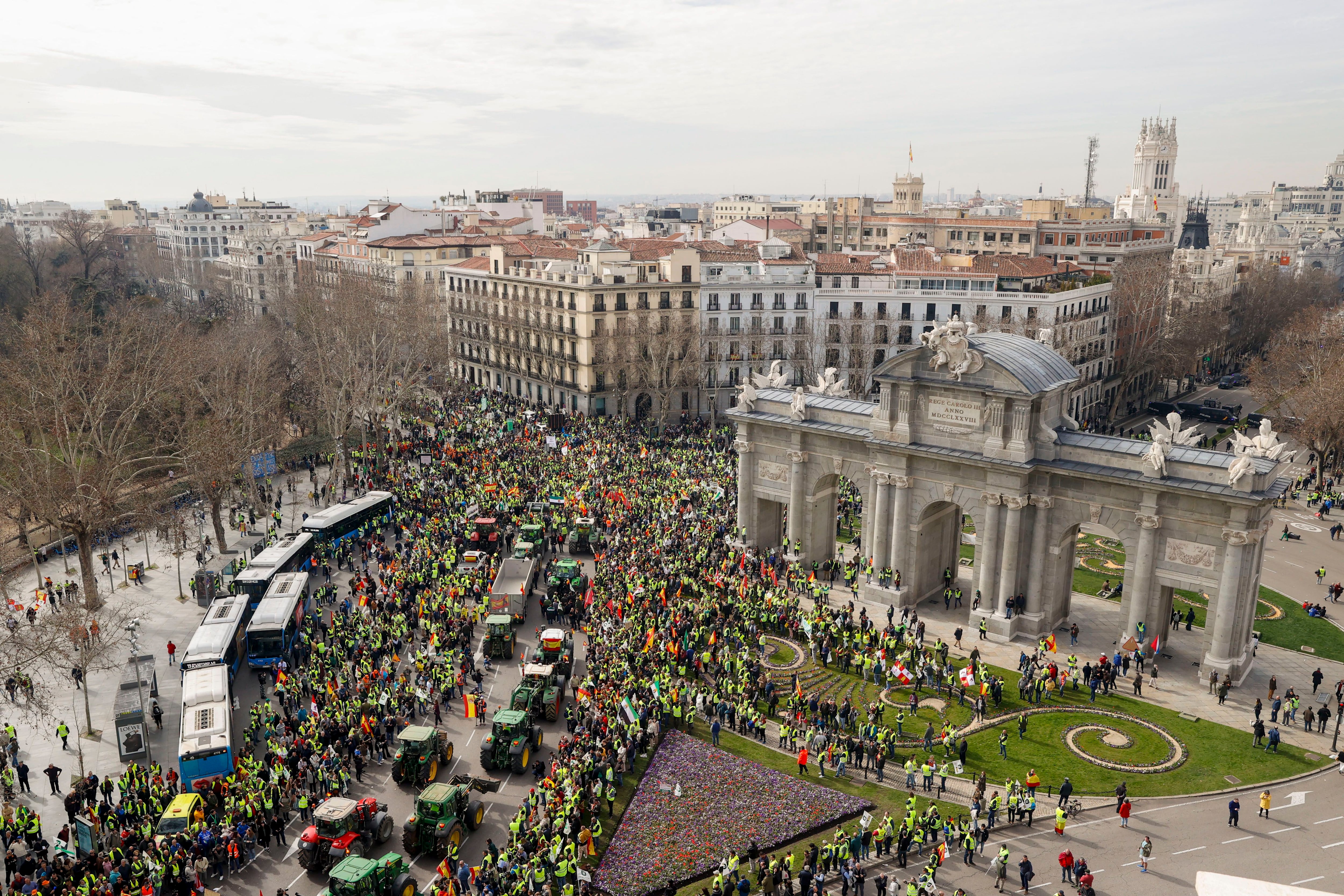 Los tractores de los agricultores procedentes de diversos puntos, a su paso por la Puerta de Alcalá, se concentran este miércoles en Madrid, en demanda de mejoras para la situación del sector agrícola.