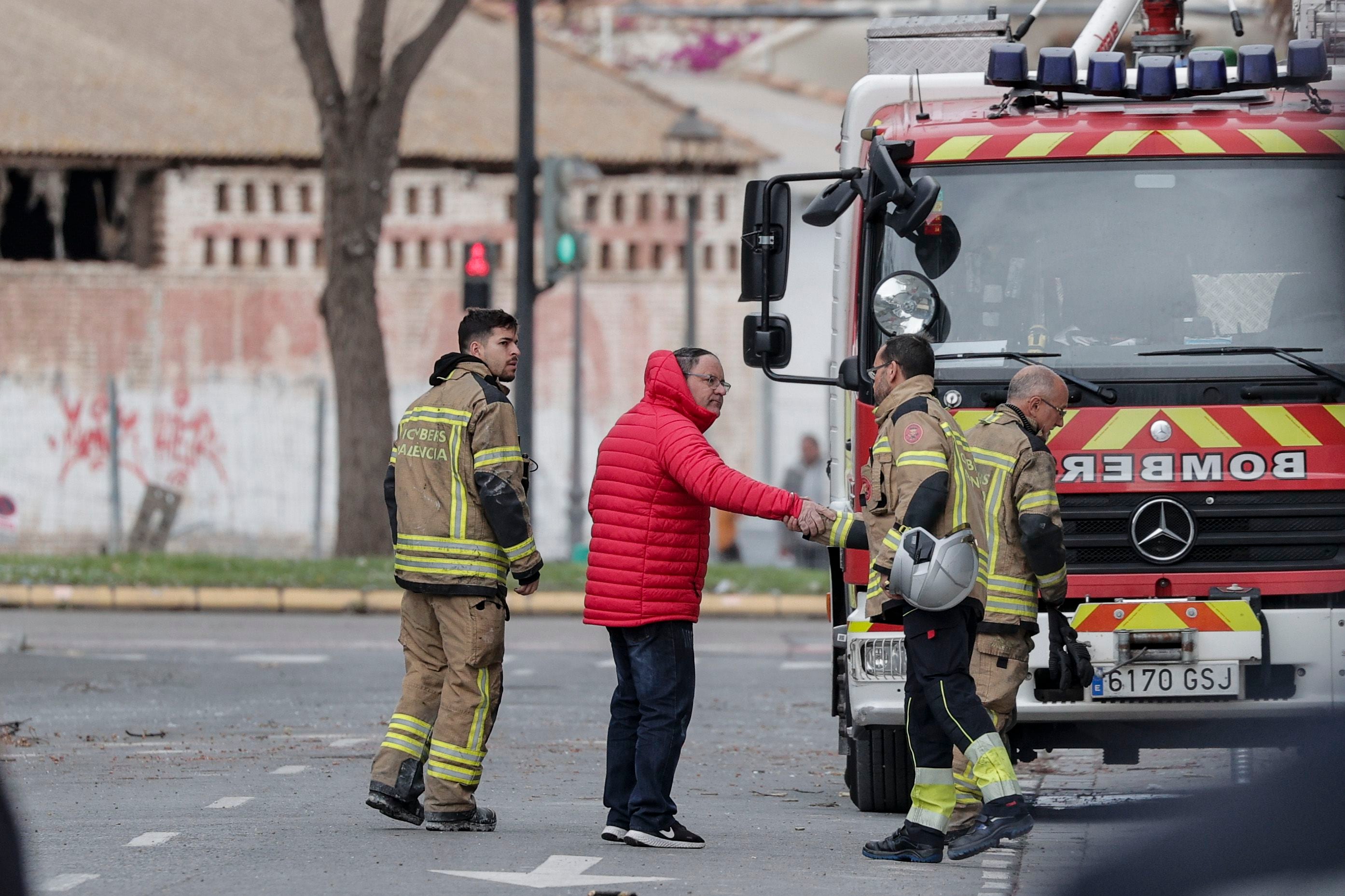 GRAFCVA8678. VALENCIA, 25/02/2024.- Julián el portero del edificio devastado por un incendio en el que han fallecido 10 personas en el barrio de Campanar de Valéncia, saluda, este domingo, a varios bomberos que permanecen junto al lugar del siniestro. EFE/Manuel Bruque
