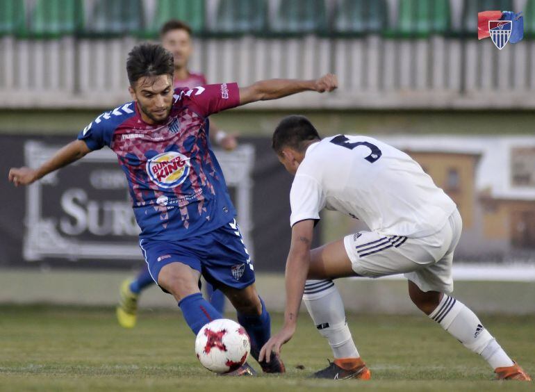 El gimnástico Álex Conde intenta zafarse de la marca de Víctor durante el partido entre la Gimnástica Segoviana y el Real MAdrid Castilla. 