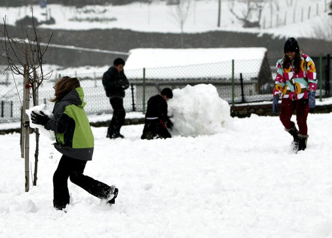 Varios niños juegan con la nieve en la localidad guipuzcoana de Berastegi. El temporal de frío y nieve anunciado desde el sábado ha dejado imágenes blancas en todo el País Vasco