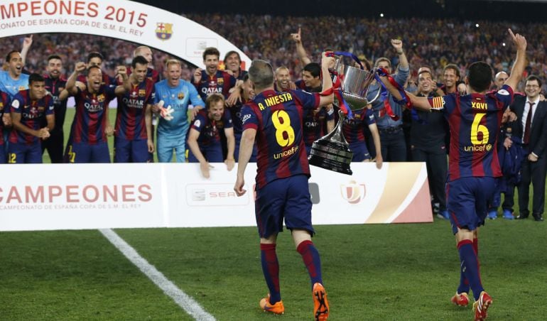 GRA422. BARCELONA, 30/05/2015.- Los centrocampistas del FC Barcelona Andrés Iniesta (i) y Xavi Hernández (d) portan la Copa del Rey que han ganado hoy frente al Athletic de Bilbao, tras vencer 1-3 en el partido de la final jugado esta noche en el Camp Nou