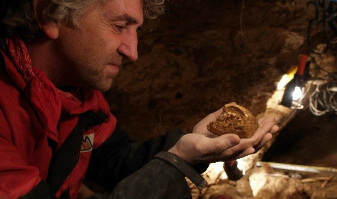 El profesor Juan Luis Arsuaga examina una de las piezas en la Sima de los Huesos