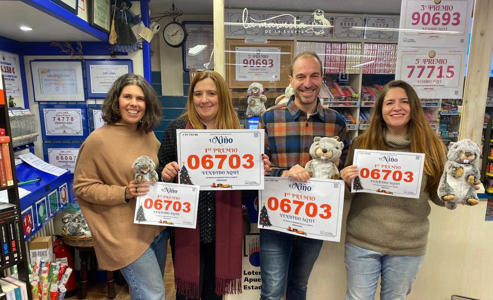 Los trabajadores de la Marmota de la suerte de Benasque, mostrando el Gordo de la Lotería de El Niño