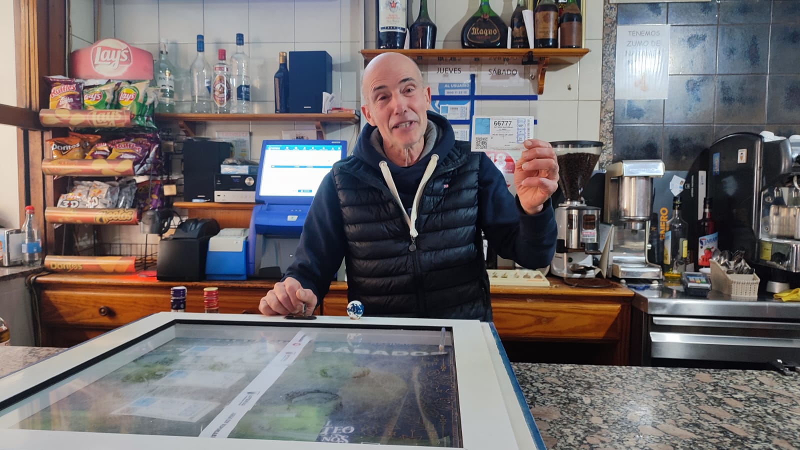 El propietario del bar Porta del Sol de Oliva con uno de los décimos agraciados.