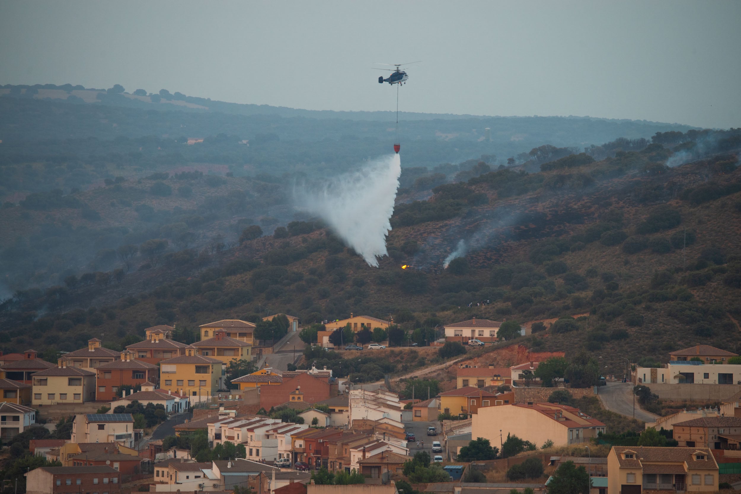 RUIDERA (CIUDAD REAL), 25/07/2022.- Efectivos del Servicio de Extinción de Incendios de Castilla-La Mancha (Infocam) luchan este lunes para evitar que el incendio forestal que se encuentra activo en el Parque Natural de Las Lagunas de Ruidera, en la provincia de Ciudad Real, pueda afectar a la urbanización &quot;Los Villares&quot;. EFE/Jesús Monroy
