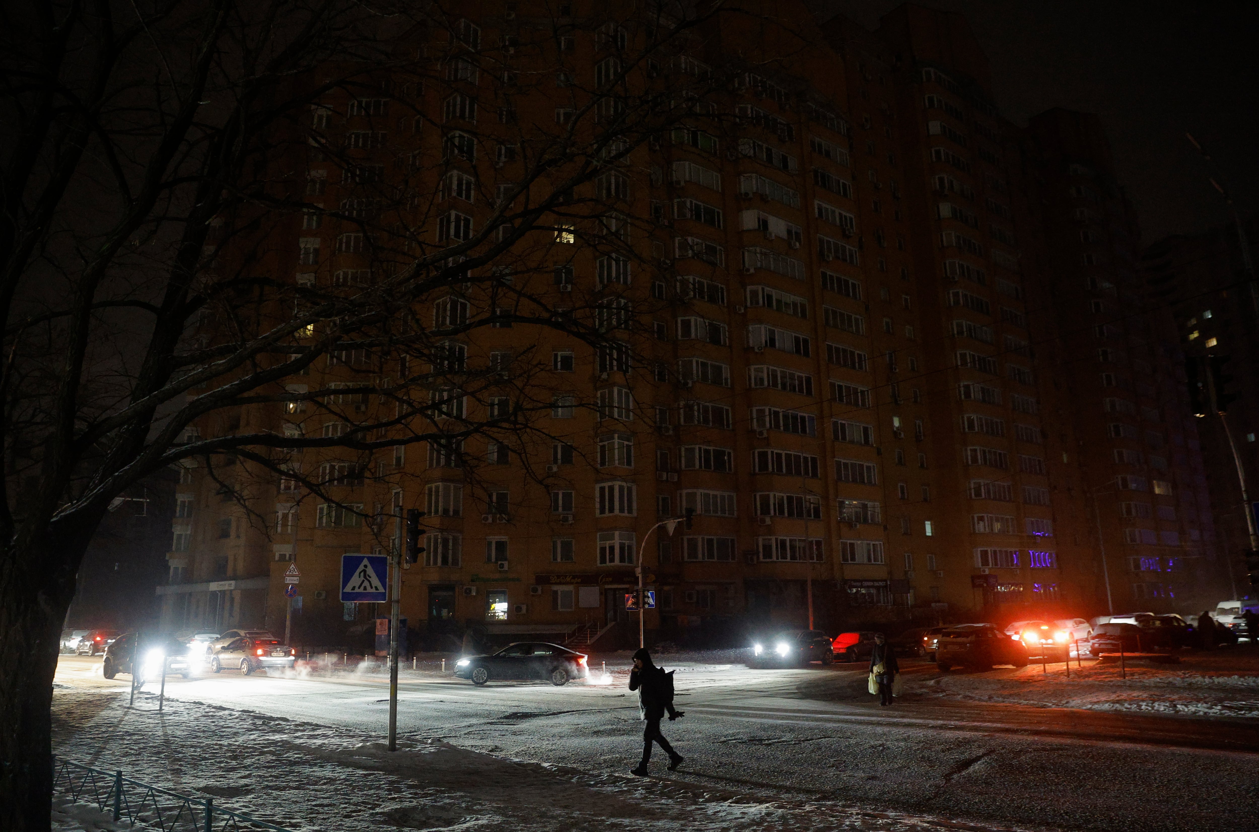La gente camina con linternas por las calles oscuras durante un corte de electricidad en Kiev, Ucrania, el 13 de enero de 2026, en medio de la invasión rusa en curso.