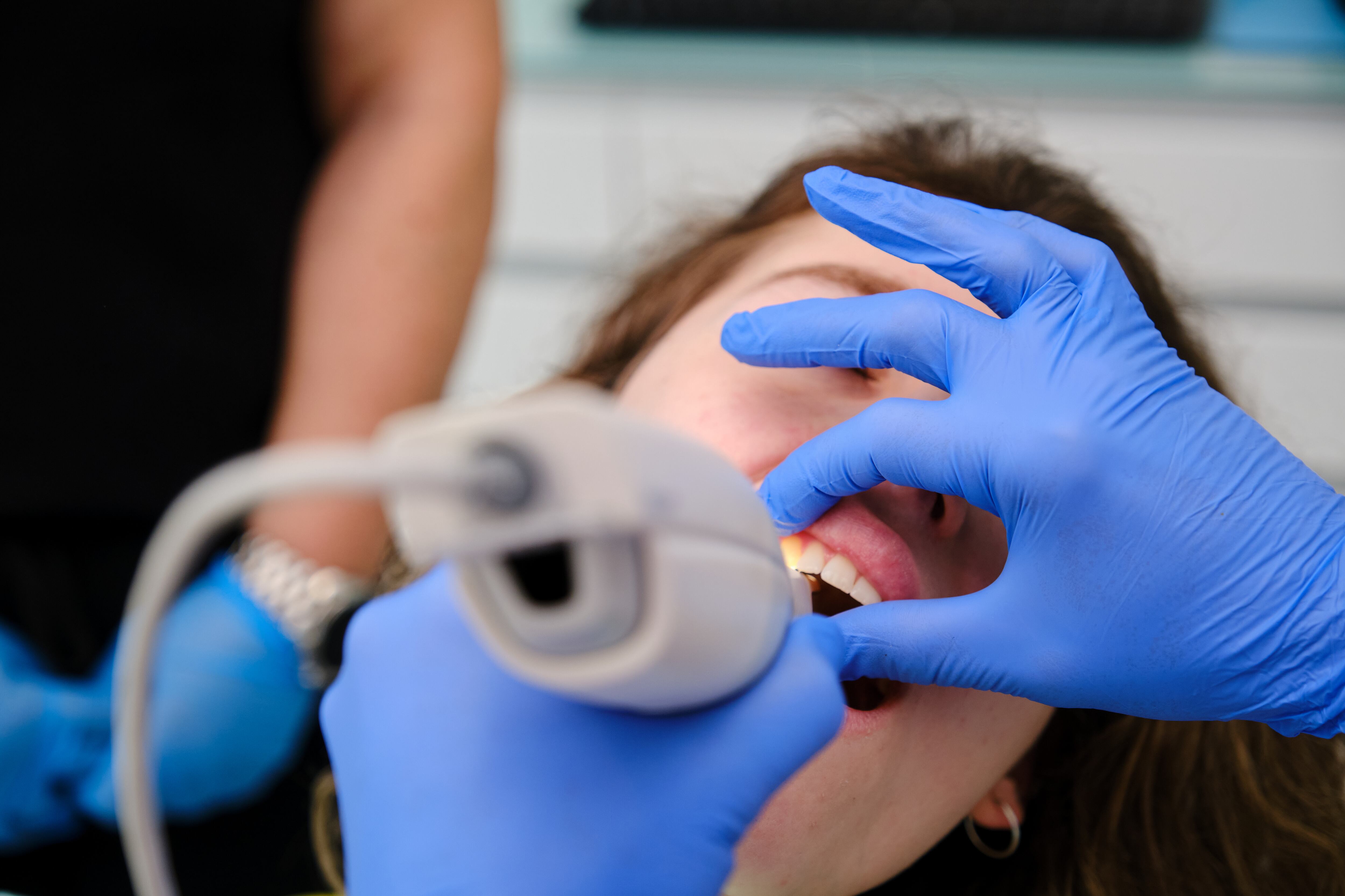 Un dentista realizando una exploración a una paciente