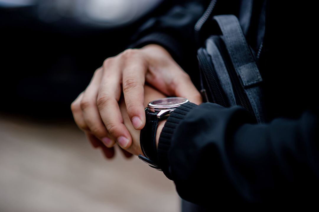 Un hombre mira su reloj