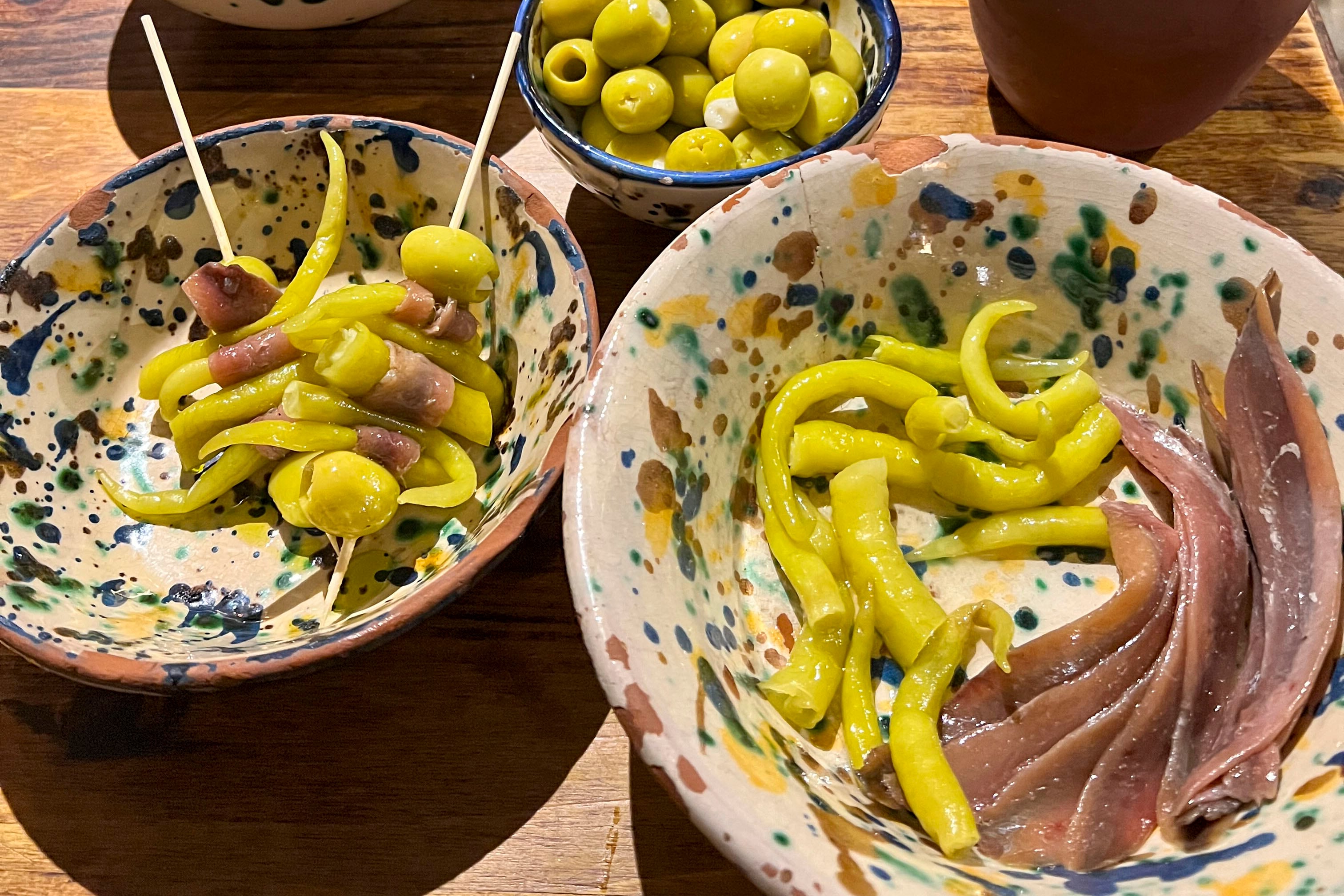 MADRID, 08/12/2025.- Han pasado más de 80 años desde que Antxon Vallés ensartara en un palillo anchoa, piparras y aceitunas bajo el nombre de Gilda, inspirado en la película de Rita Hayworth porque, al igual que ella, es un pincho verde, salado y un poco picante. Hoy este pincho trasciende las barras de bar como icono millennial. La transformación cultural de la gilda tiene un punto generacional y otro simbólico. Nacida en la posguerra como un bocado sencillo, se convierte en un emblema emocional que une tradición y modernidad, con un ascenso que encuentra reflejo en redes sociales, en el lenguaje visual de los tatuajes y en la joyería artística. EFE/Almudena González