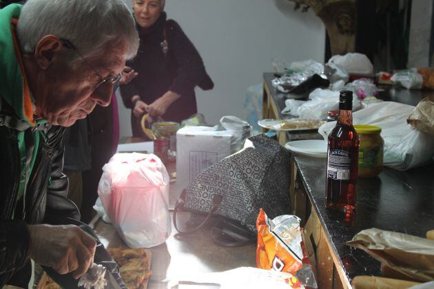 Varias personas colaboran en la preparacion de comida en el interior de la parroquia San Carlos Borromeo.