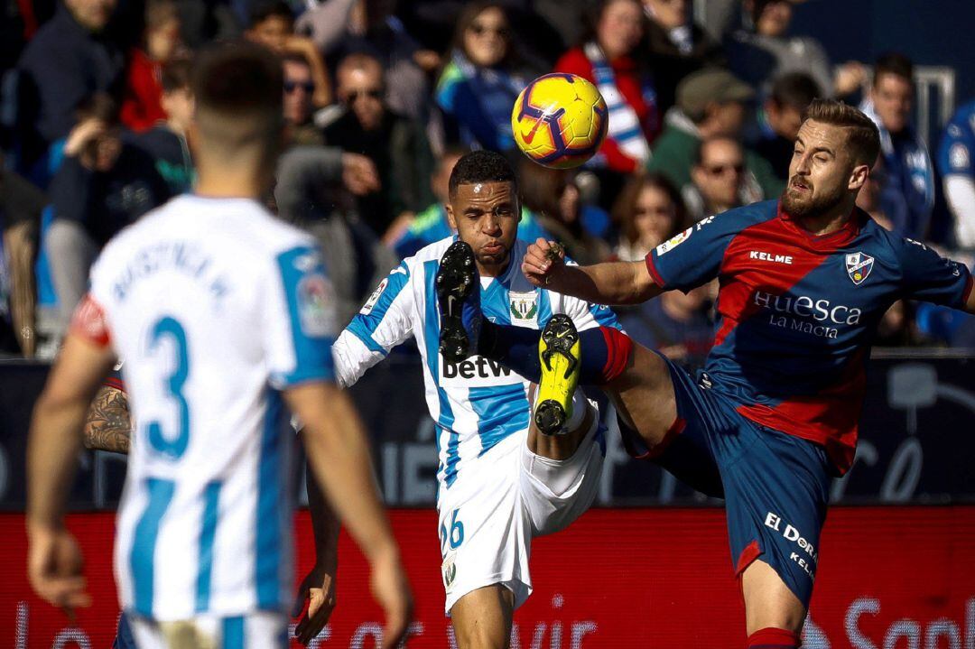 El delantero del Legané Youssef En-Nesyri (c) y el defensa del Huesca Jorge Pulido (d) durante el partido de la decimonovena jornada de Liga que disputan ante el Leganés en el estadio de Butarque.