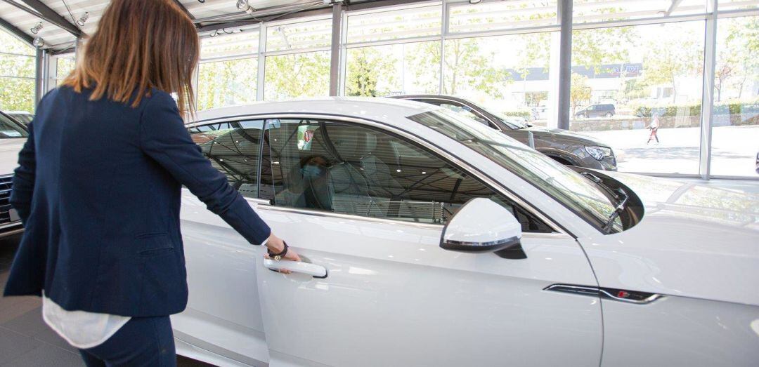 Una mujer abre un coche en un concesionario.