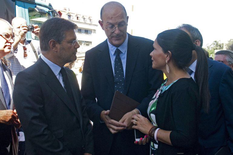 El ministro de Justicia en funciones, que ha asumido la cartera de Fomento, Rafael Catalá, conversa con la alcaldesa de Mos, Nidia Arévalo y un directivo de Renfe, en la zona de O Porriño (Pontevedra), donde hoy se ha producido un accidente ferroviario en