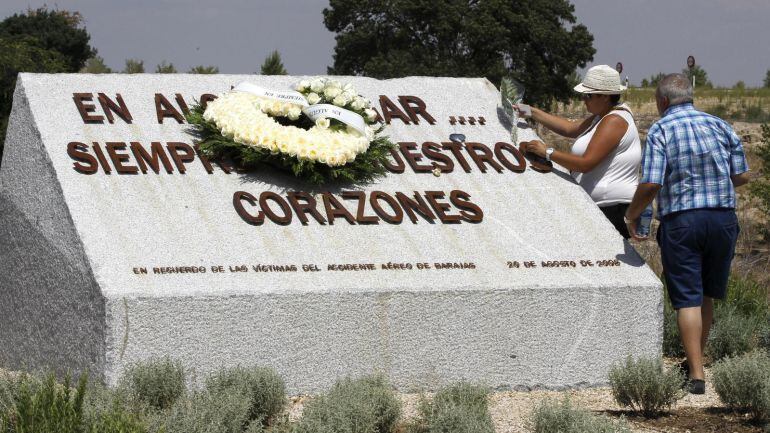 Familiares de las víctimas del accidente depositan ofrendas florales en el monumento ubicado en Barajas. 