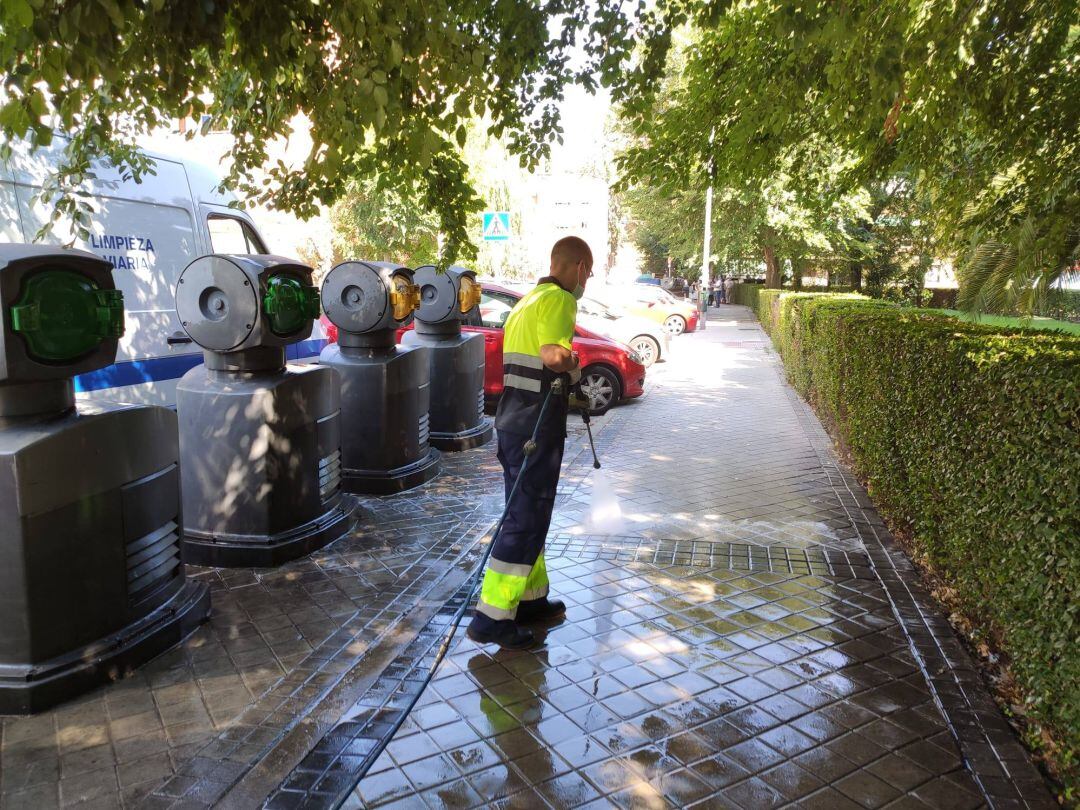 Un operario municipal limpia una zona de contenedores de Leganés en verano de 2020.