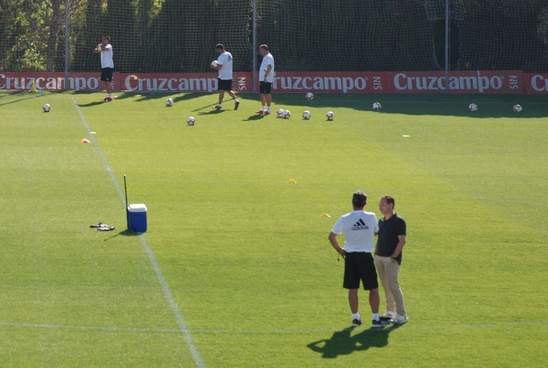David Navarro charla con Álvaro Cervera durante un entrenamiento. Al fondo Javi Manzano