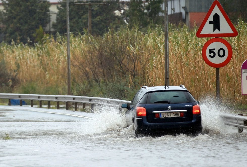 Un coche pasa por una balsa de agua en una carretera próxima a la localidad de Asua, en Bizkaia. 