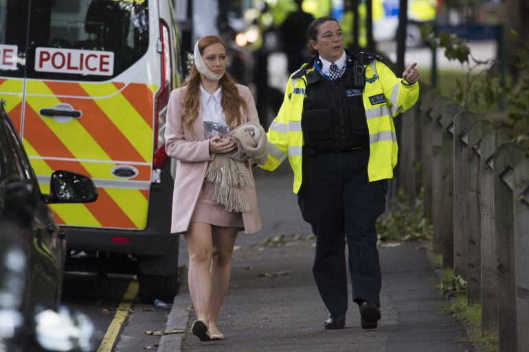 Una agente de policía escolta a una herida en los alrededores de la estación de metro Parsons Green en Londres (Reino Unido).