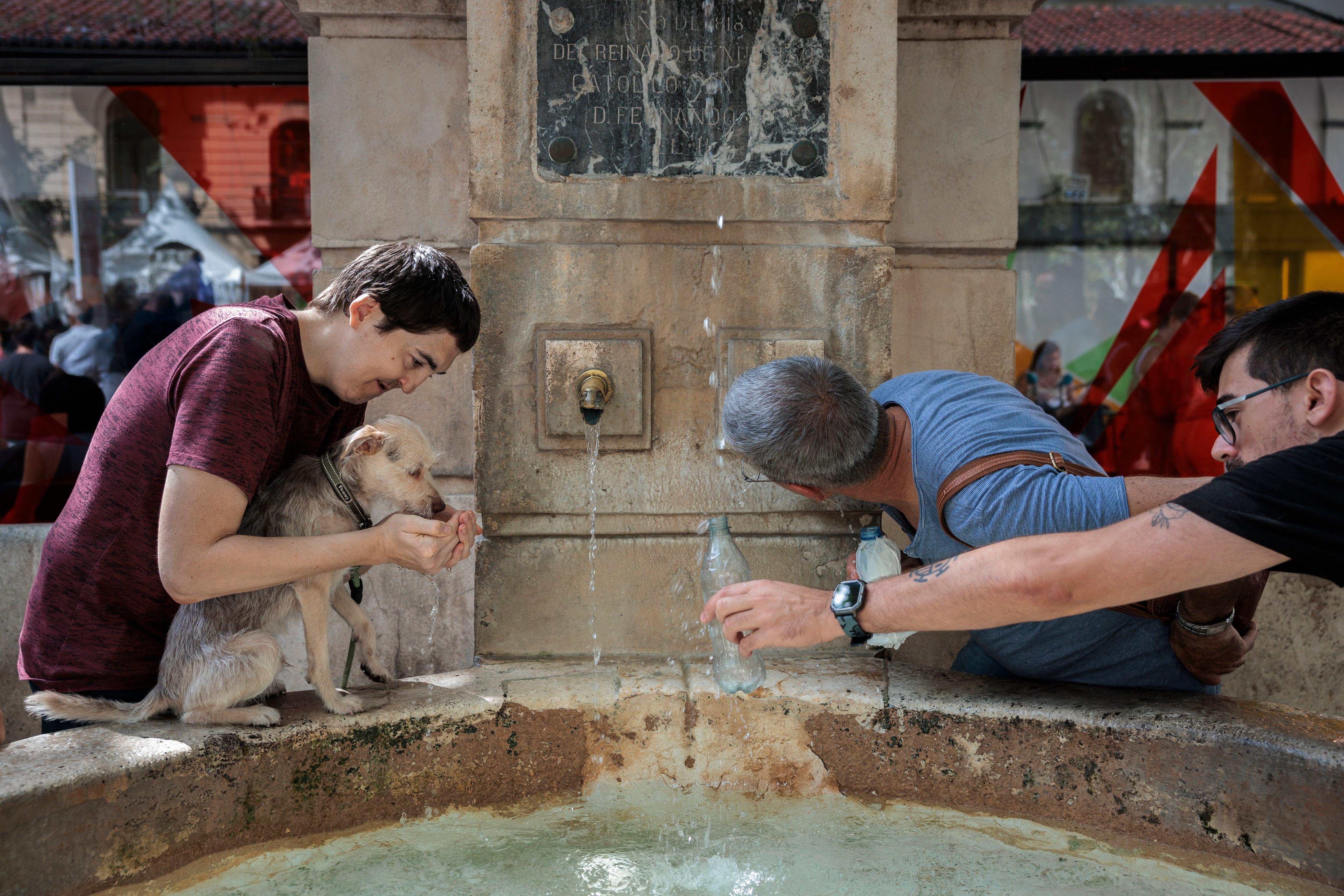 XÀTIVA (COMUNIDAD VALENCIANA), 15/08/2023.- Varias personas se refrescan en una fuente en la localidad valenciana de Xàtiva este martes. EFE/Biel Aliño
