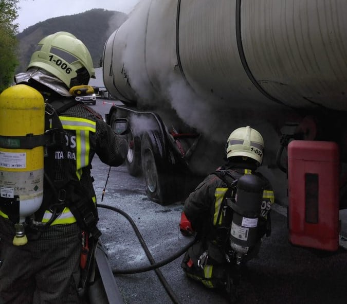 Bomberos sofocando el incendio del neumático de un camión cisterna.