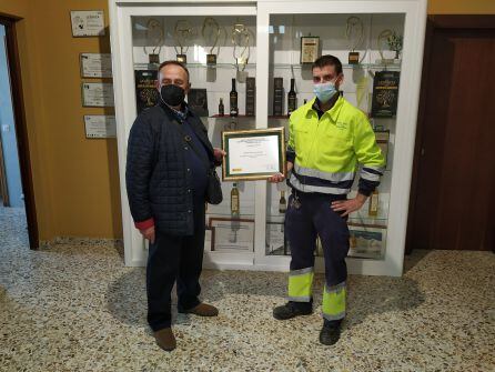 El presidente de la Cooperativa, Manuel Ogallar (izquierda) y el maestro de almazara, Cristóbal Balboa, muestran algunos de los reconocimientos recibidos