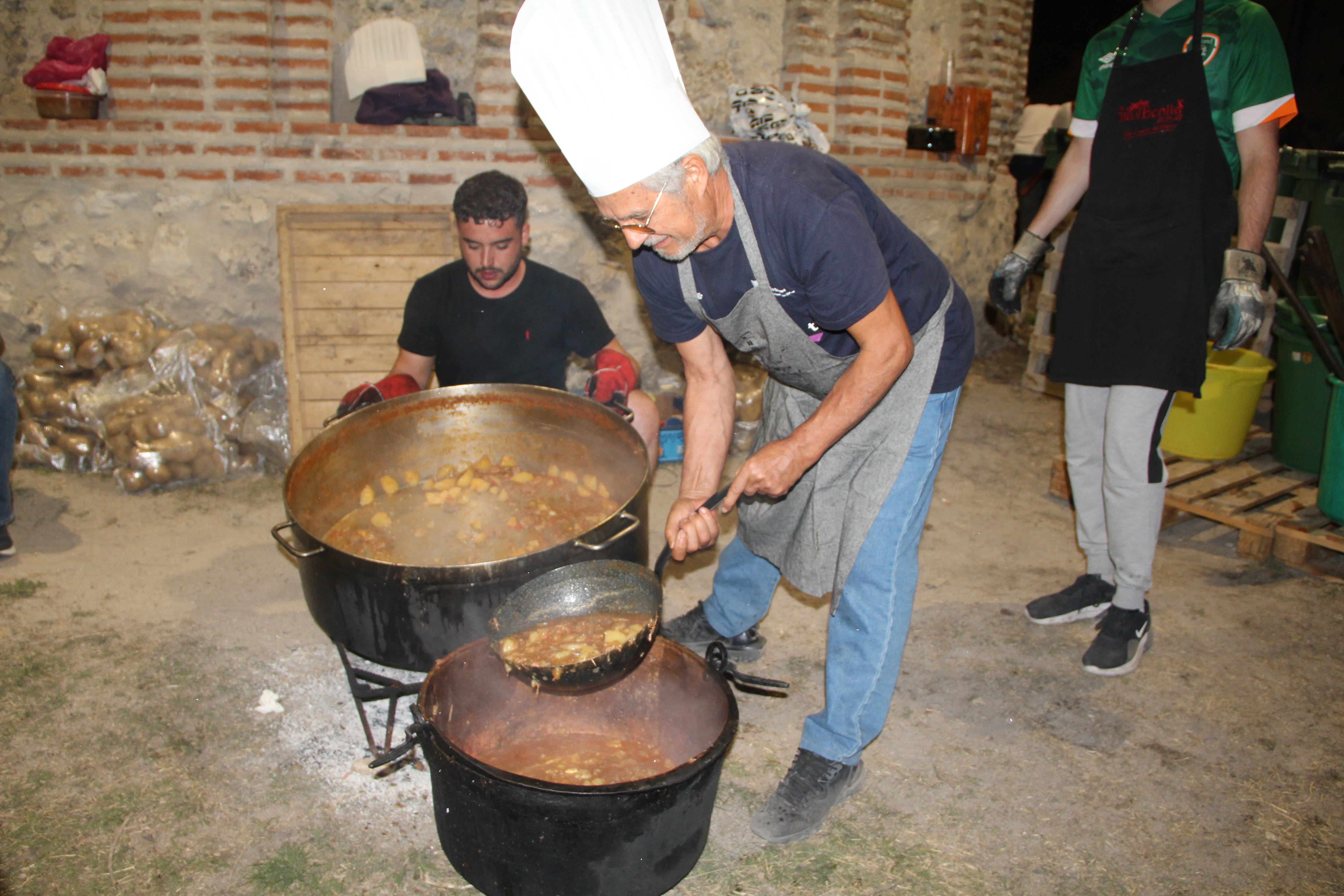 Un hombre cocina las populares patatas en el barrio de El Salvador de Cuéllar