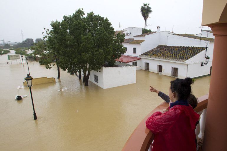 Varias personas observan el estado de sus casas inundadas en la barriada Doña Ana de la localidad de Cártama por las fuertes lluvia caídas esta noche. El servicio Emergencias 112 Andalucía ha registrado 180 incidencias en las últimas horas en la provincia