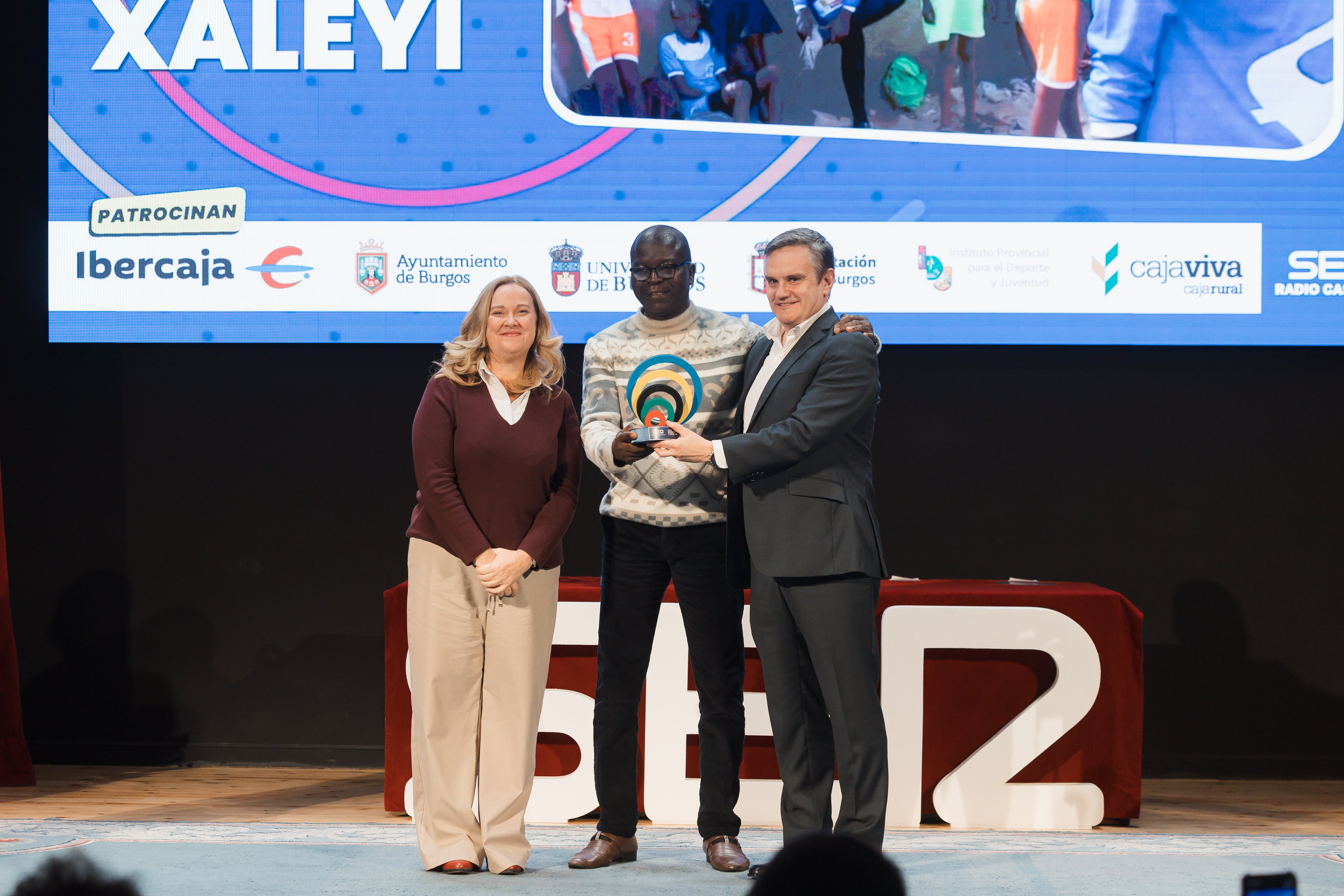 Cristina Ayala, alcaldesa de Burgos, entregó el galardón a la Academia 'Jammu Xaleyi' de fútbol femenino de Senegal. Junto a ella, Moustaphá Cissé (África Camina) y Nacho Solana (Oé Oé Marketing). / Foto: Rodrigo Mena