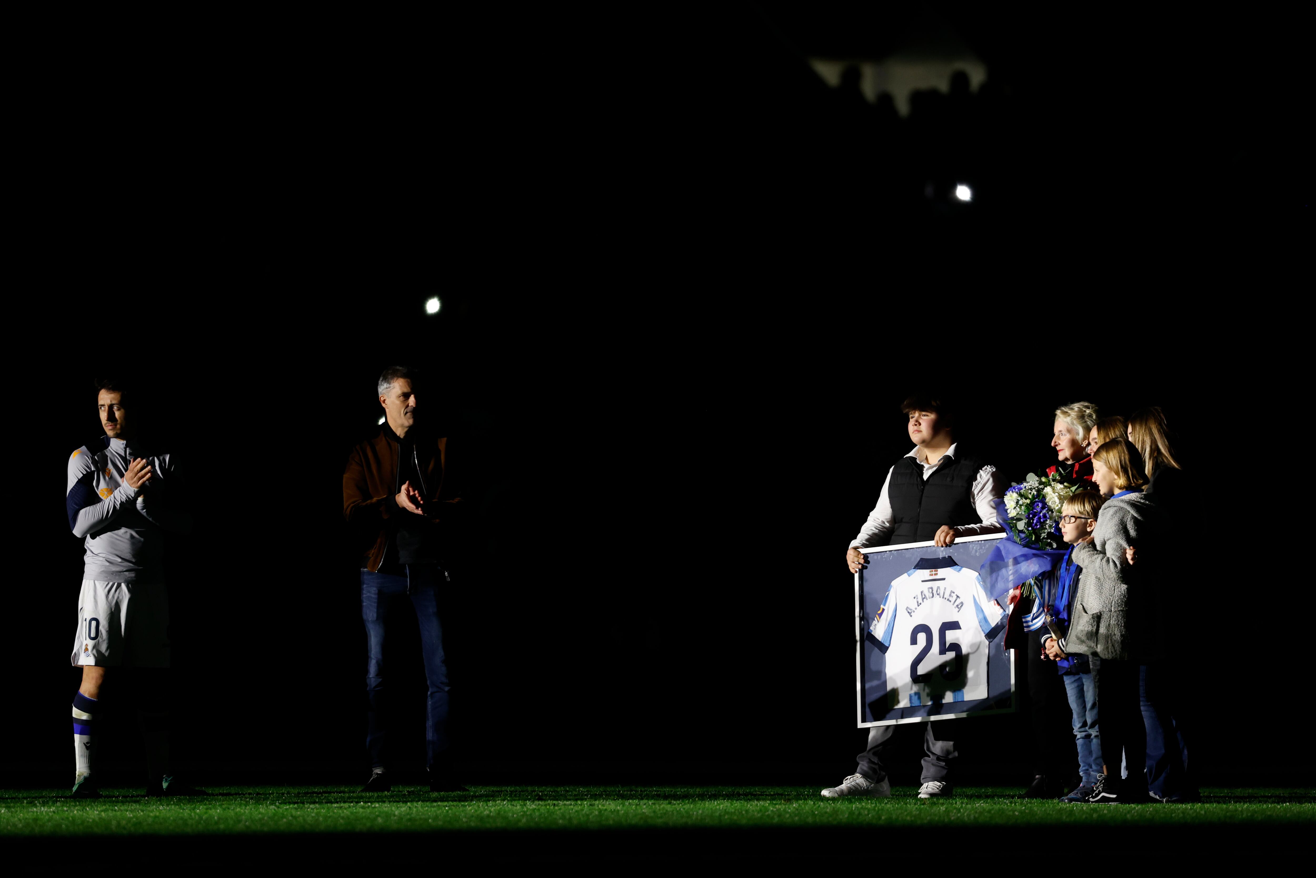 -FOTODELDÍA- SAN SEBASTIÁN, 17/12/2023.- El capitán de la Real Sociedad Mikel Oyarzabal (i) hace entrega de un recuerdo a la familia del aficionado Aitor Zabaleta, asesinado hace 25 años de una puñalada en el corazón cerca del estadio Vicente Calderón, durante el homenaje ofrecido tras el encuentro entre Real Sociedad y Betis correspondiente a la jornada 17 de LaLiga Santander, este domingo en el Reale Arena de San Sebastián. EFE/Javier Etxezarreta
