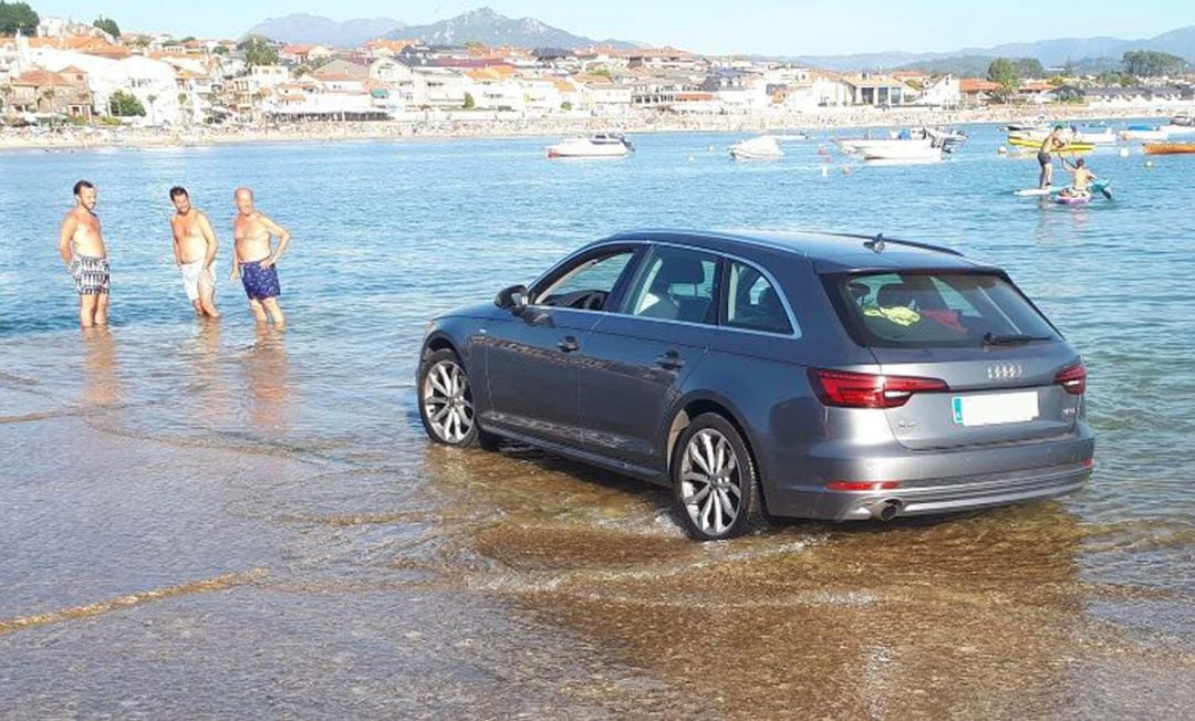 Coche a punto de ser engullido por la marea