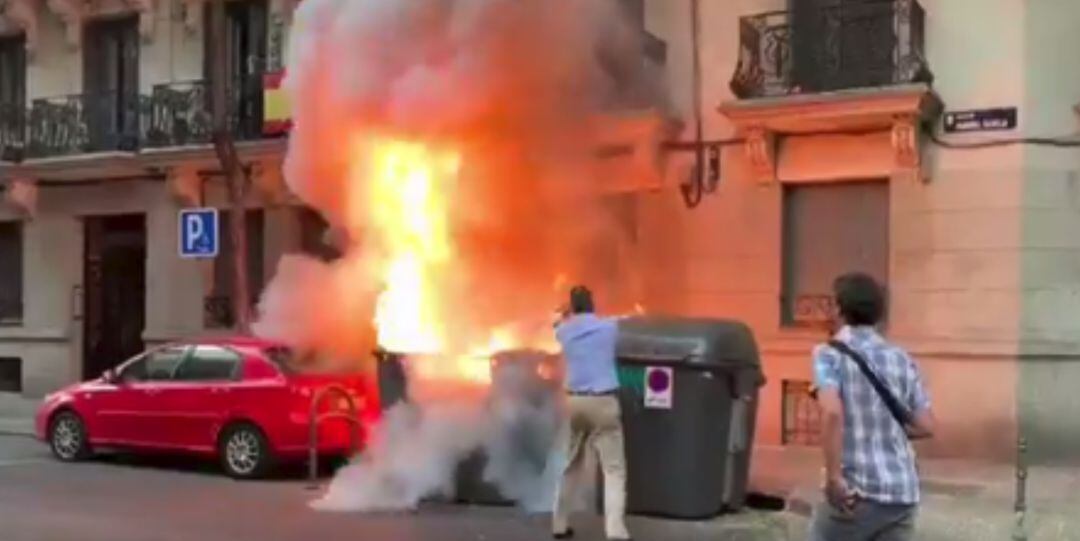 Ortega Smith, secretario general de Vox y diputado, ayuda a sofocar las llamas de un contenedor frente a su sede en Madrid.