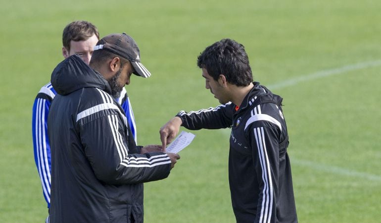 GRA043. PATERNA (VALENCIA), 17/04/2015.- El entrenador del Valencia, Nuno Espiritu Santo (i), conversa con el jugador, Dani Parejo (d), durante el entrenamiento realizado esta mañana en la ciudad deportiva del club, para preparar el encuentro de Liga que disputarán mañana en el Camp Nou frente al Barcelona. EFE/Manuel Bruque