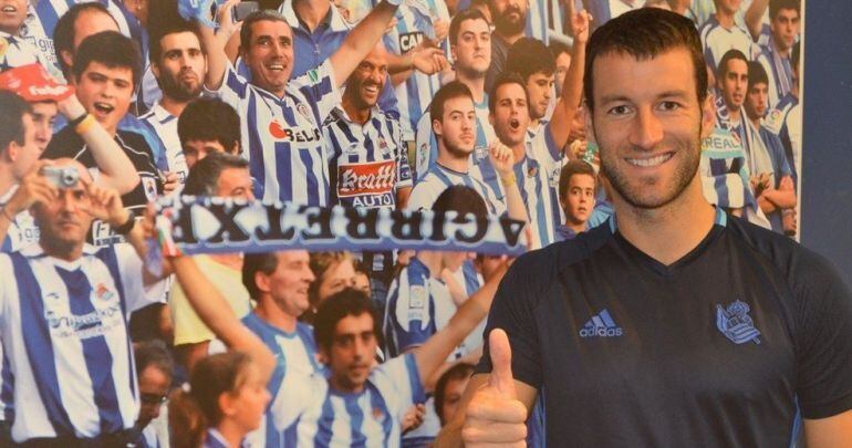 Agirretxe posa junto a una foto de aficionados de la Real Sociedad