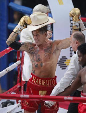 El actor y boxeador estadounidense Mickey Rourke saluda tras vencer el combate