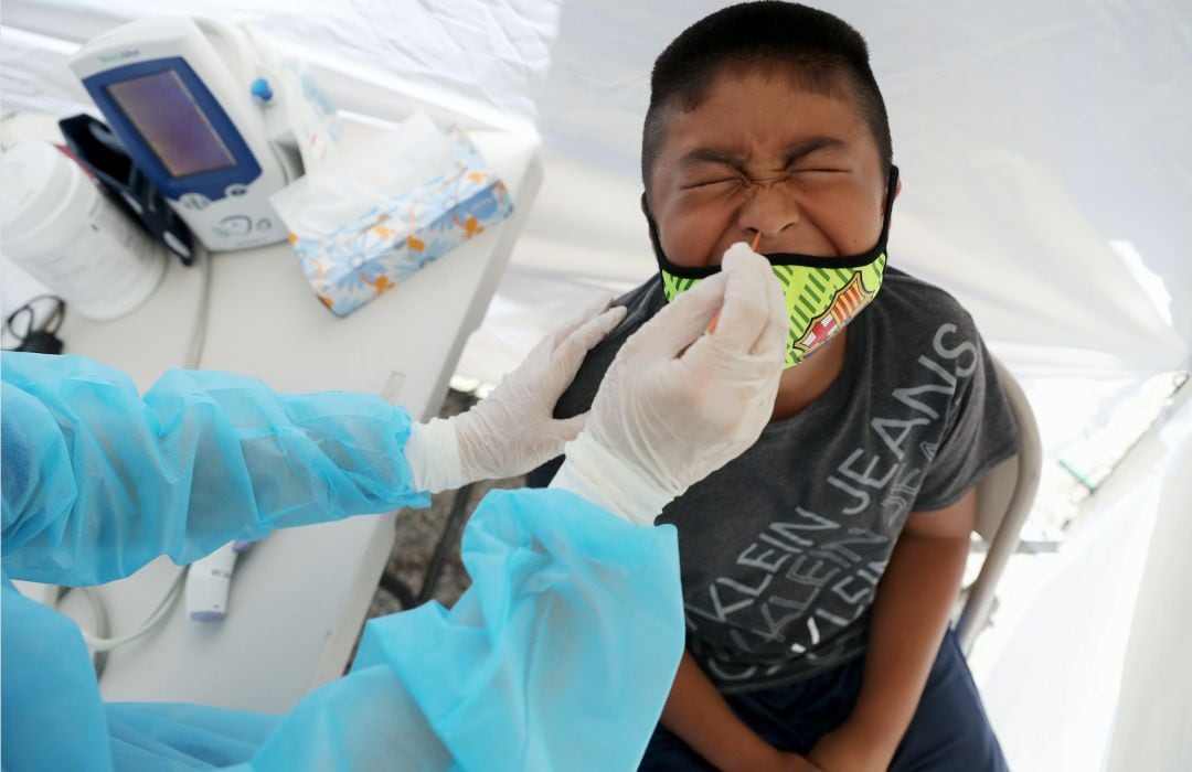 Un niño recibe una prueba gratuita de Covid-19 en una clínica móvil de St. John’s Well Child & Family Center situada fuera de la iglesia Walker Temple AME, en el sur de Los Ángeles (EEUU)