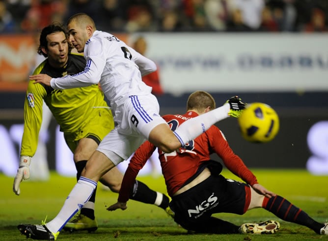 Benzema lucha por el balón ante el portero del Osasuna durante el partido de la 21ª jornada de la Liga BBVA