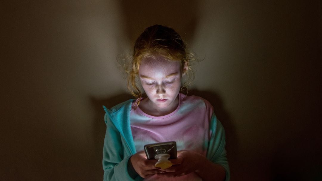 Imagen de recurso de una niña con un teléfono móvil