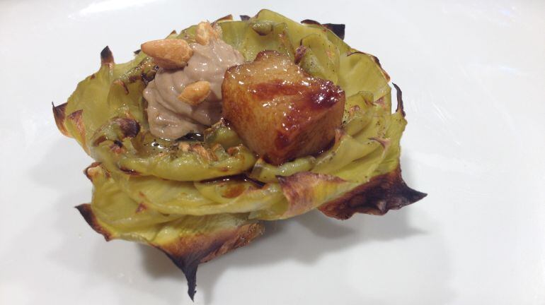 Alcachofa con papada ibérica, teriyaki de regaliz, mayonesa de ajo negro y piñones.