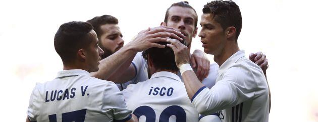 Isco y Bale se abrazan con sus compañeros después de un gol del malagueño