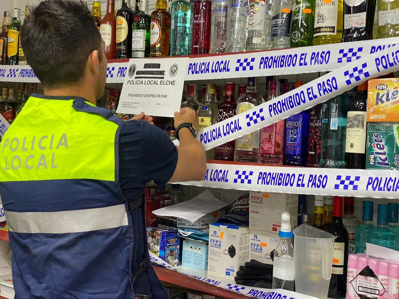 Un agente de la Policía Local de Elche precintando bebidas alcohólicas