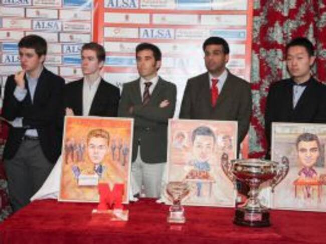 Los participantes posan ante sus retratos