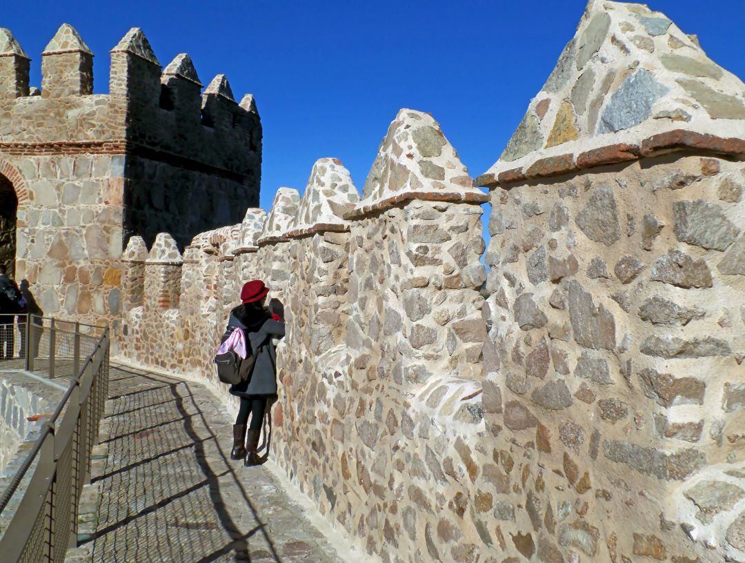 Una turista realiza una foto desde uno de los tramos del adarve de la Muralla