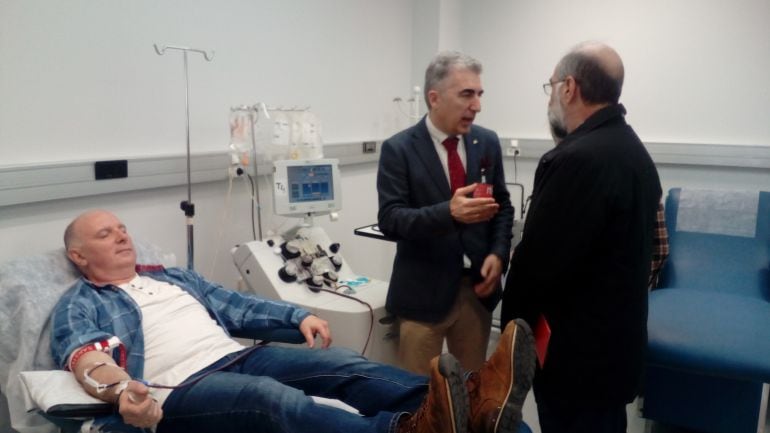 El director del Banco de Sangre y Tejidos de Navarra, José Antonio García Erce, conversa con el consejero de Salud, Fernando Domínguez (de espaldas) mientras Antontxu Contreras Orzaiz dona su sangre en las instalaciones del Banco en el Complejo Hospitalar