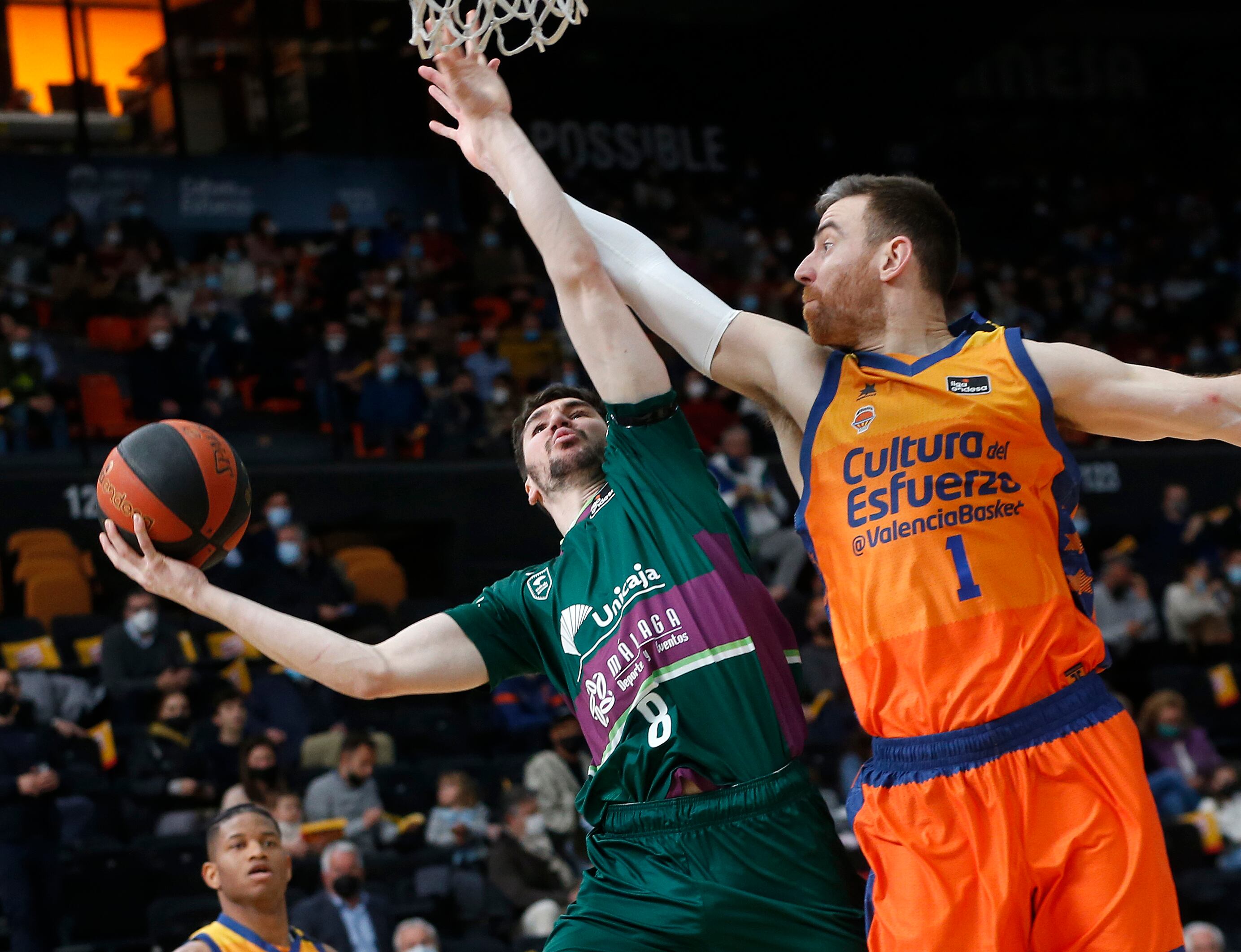 El jugador de Unicaja Málaga Dario Brizuela lanza a canasta ante el ala-pívot de Valencia Basket Victor Claver, durante en el encuentro de la fase regular de la Liga Endesa disputado hoy domingo en el pabellón Fuente de San Luis de Valencia. EFE/Miguel Ángel Polo