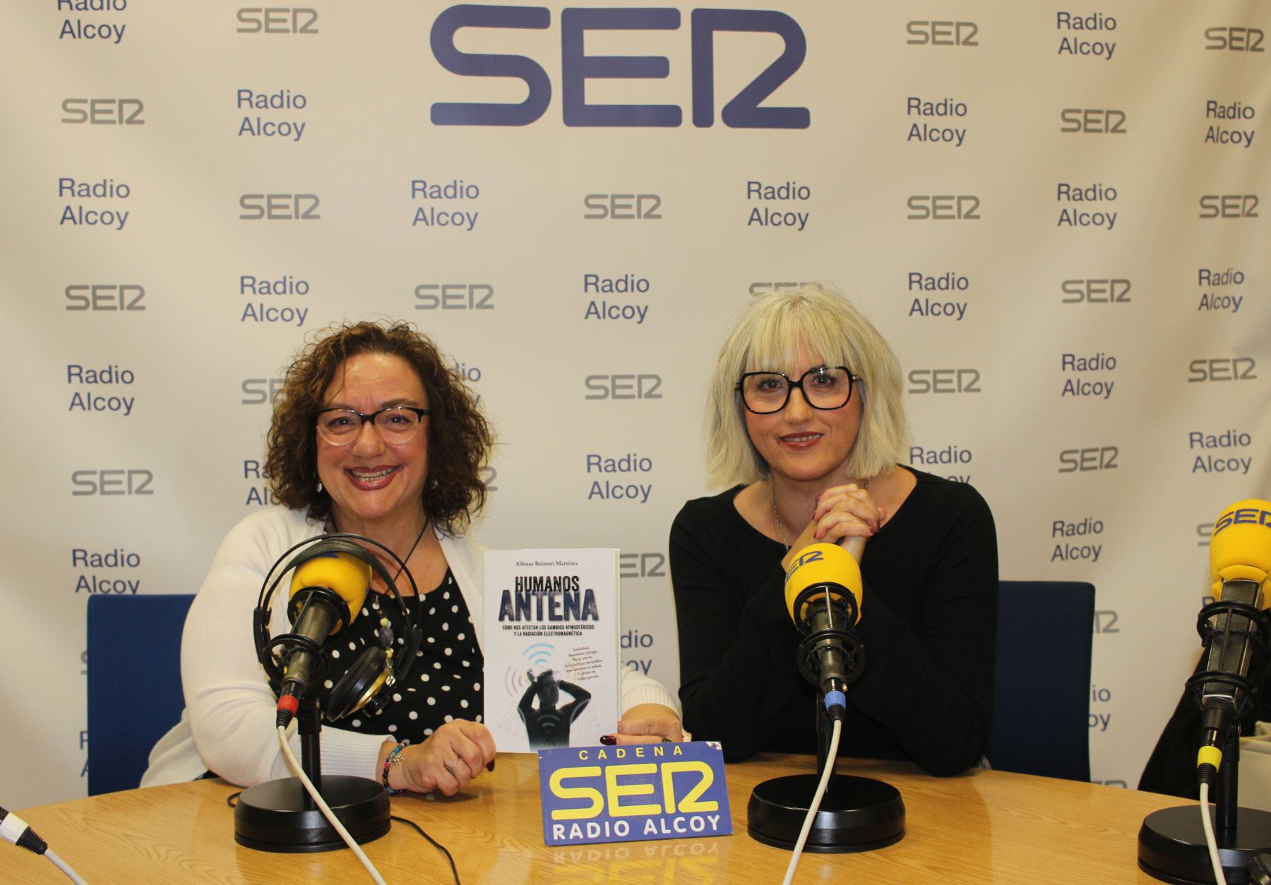 Begoña Doménech y Begoña Beneyto, con un ejemplar del libro 'Humanos antena' en el estudio central de Radio Alcoy