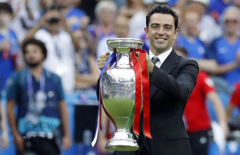 Xavi posa con el trofeo en el césped del Estadio de Francia.