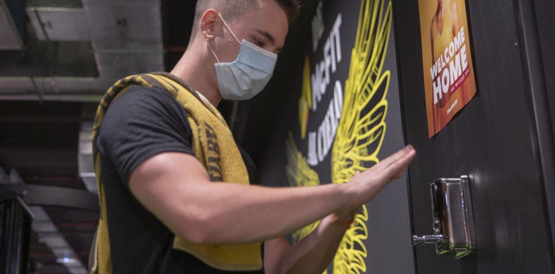 Una persona con mascarilla se lava las manos con hidrogel.